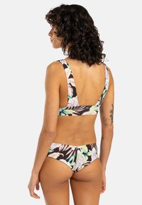 Blommig bikiniset med svart bakgrund och tropiska blad- och blommönster. Tjocka band, medelhög täckning på underdelen och mjuk textur.