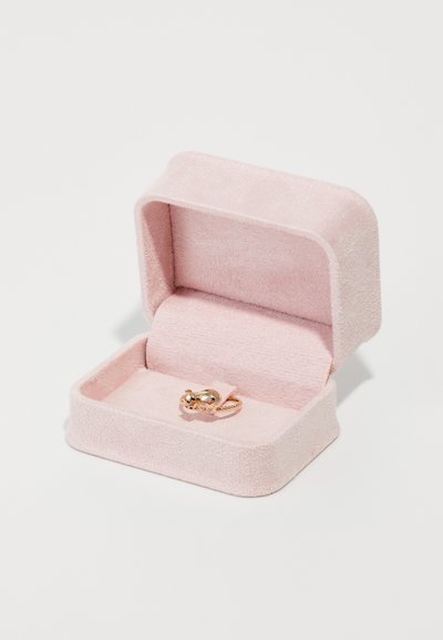 Ροζ βελούδινο κουτί δαχτυλιδιού με ένα χρυσό δαχτυλίδι στο εσωτερικό, που διαθέτει λεπτομερή σχέδιο. Το κουτί έχει απαλή υφή και στρογγυλεμένες γωνίες.