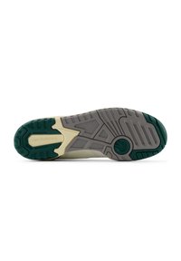 Sole di una sneaker con una suola in gomma verde e grigia, dotata di una superficie testurizzata e di motivi geometrici; "New Balance" in rilievo.
