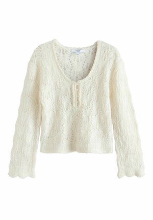 Kremfarvet strikket sweater med bølgede kanter, lange ærmer, rund halsudskæring og tre små knapper på frontklappen.