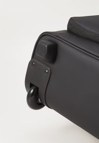 Black wheeled bag with a smooth texture, featuring a sturdy handle and a rounded, glossy wheel for easy transport.