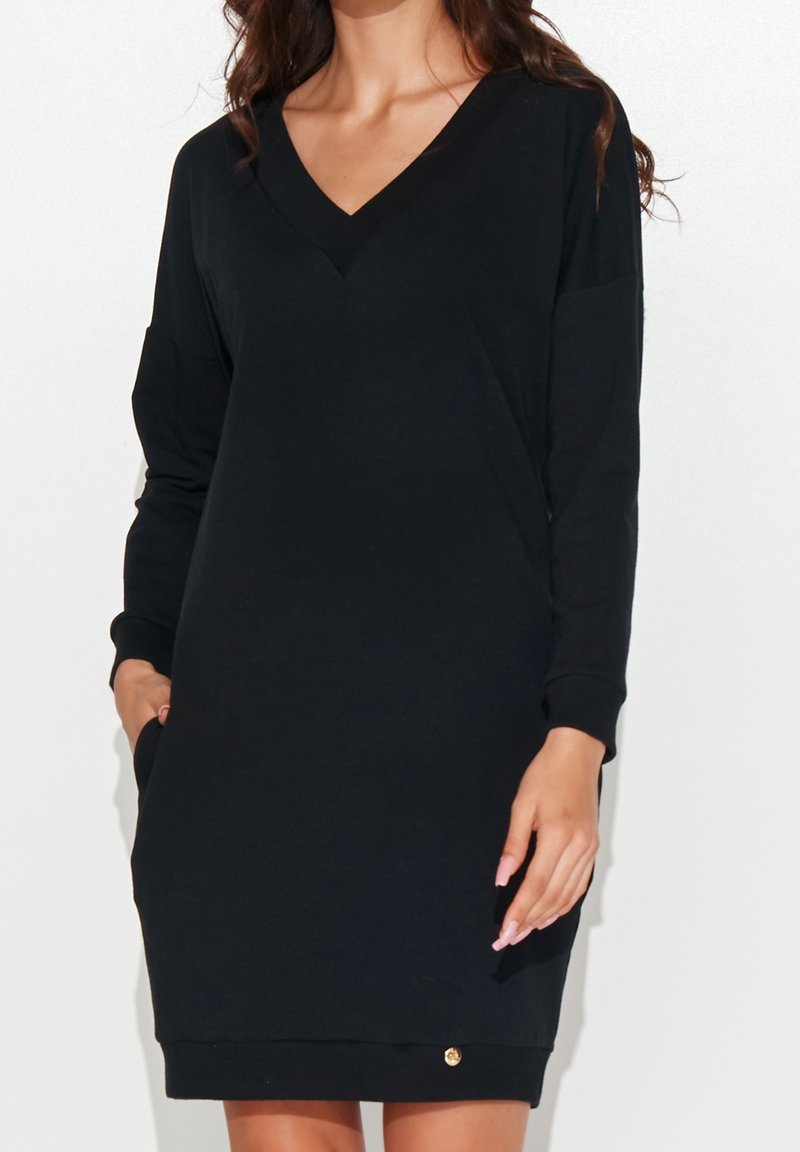 Schwarzes Sweatshirtkleid mit V-Ausschnitt, langen Ärmeln und einem lockeren Schnitt. Verfügt über seitliche Taschen und einen kleinen goldenen Akzent am Saum.