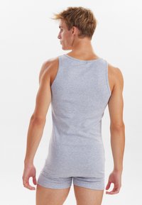 Grå bomulds tanktop med rund hals, parret med matchende grå shorts. Stoffer ser bløde ud med en glat tekstur.