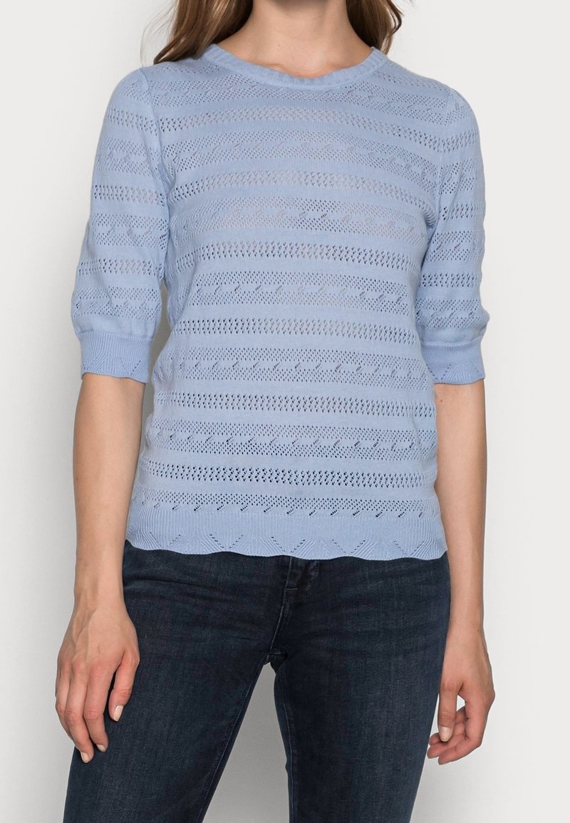 Maglione azzurro chiaro lavorato a maglia con scollatura rotonda, maniche a tre quarti e strisce testurizzate orizzontali e verticali. Dettaglio con orlo scallop.