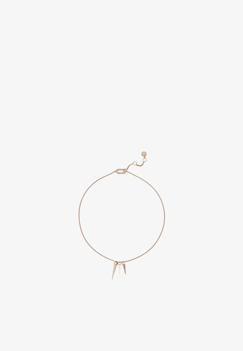 Bracelet ton or avec une fine chaîne, ornée de deux breloques métalliques pointues et d'un petit fermoir rond pour une longueur ajustable.