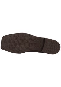 Suela de zapato de goma marrón con una superficie texturizada, que presenta un agarre con patrón y un diseño plano. Borde redondeado notable en la punta.