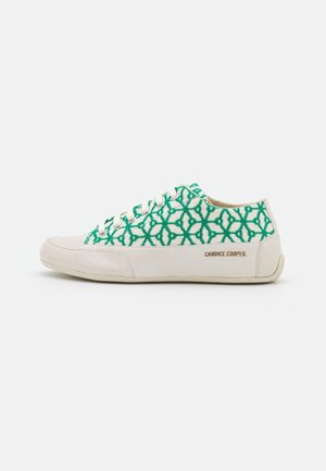 Zapatilla de perfil bajo con suela y puntera beige, parte superior de tela con patrón geométrico verde, cordones crema y marca "Candice Cooper" en el costado.