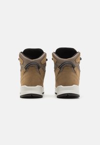 Scarpe alte con tomaia in suede marrone e rete grigia, suola in gomma bianca e dettagli neri. La vista dal retro mette in evidenza il design del tallone e del collo.