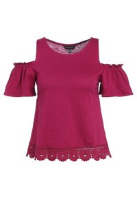 Top fucsia con hombros descubiertos y mangas cortas abullonadas, con un borde de encaje festoneado en el dobladillo. Hecho de un material suave y ligero.