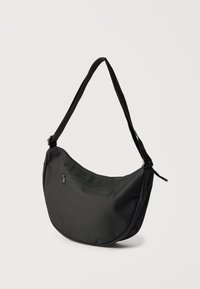 Mustast poolkuu kujuline õlakott reguleeritava rihma ja esiosas oleva välise lukuga taskuga, taust on ühtlane.