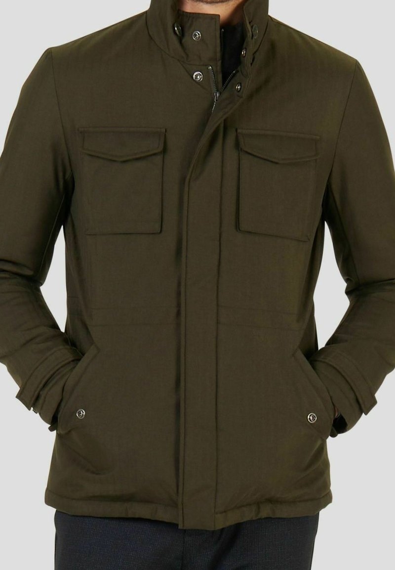 Giacca zip-up verde oliva con colletto a polo, due tasche sul petto e tasche laterali, caratterizzata da una trama liscia e chiusure a scatto.