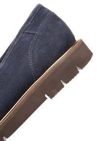 Talons de chaussure en daim bleu marine avec détails de couture, semelle en caoutchouc marron avec motif de bande de roulement, présentés sur fond blanc.