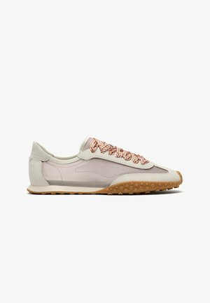 Baskets beige et gris clair profil bas avec semelle marron texturée et lacets à carreaux marron et blanc, vue latérale sur fond blanc.