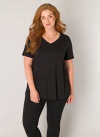 Zwarte V-hals t-shirt met korte mouwen, gemaakt van zachte stof, gecombineerd met zwarte legging. Glad textuur en een ontspannen pasvorm.