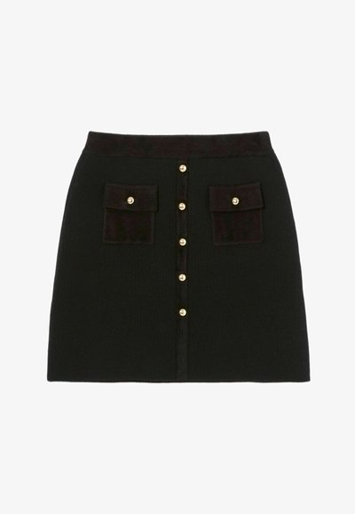 Jupe noire en tricot avec une surface texturée, dotée d'une fermeture à boutons à l'avant, de deux poches avant et de boutons dorés.