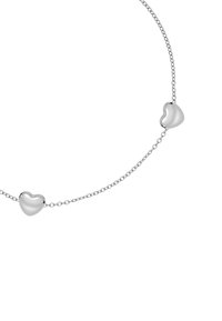 Silver chain necklace featuring two heart-shaped pendants, smooth texture, and polished finish. Minimalist design with delicate links.