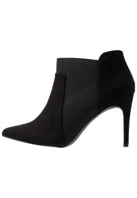 Schwarze, hochhackige Ankle Boots mit spitzem Zehenbereich, Wildleder- und Elastikeinsätzen, strukturiertem Obermaterial und einer schlanken, zulaufenden Silhouette.