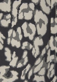 Abstrakt leopardmönstrad tyg med stora, oregelbundna grå och vita former på en svart bakgrund; slät textur och mjuk yta.