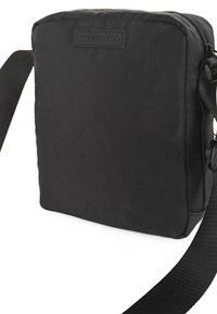 Bolsa cruzada rectangular negra hecha de tejido duradero, con cierre de cremallera y correa ajustable. Superficie texturada con detalle del logo.