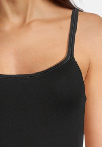 Black tank top with slim shoulder straps; made of smooth fabric featuring a curved neckline and subtle stitching details.