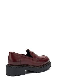 Mocassini in pelle bordeaux con punta rialzata, suola in gomma nera spessa e battistrada testurizzato per una migliore aderenza. Design minimalista con una finitura liscia.