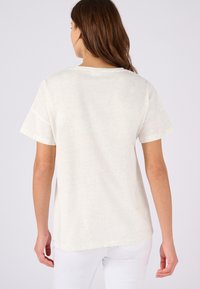 Korte mouwen, lichtbeige T-shirt van een zachte, gestructureerde stof, met een losse pasvorm en een ronde halslijn.