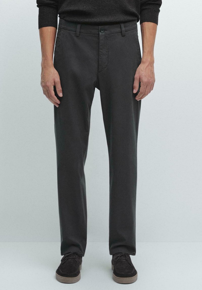 Donkergrijze broek met een slim fit ontwerp, voorzien van een vlakke voorkant, riemlussen en een enkele knoopsluiting. Gemaakt van een gladde katoenmix.
