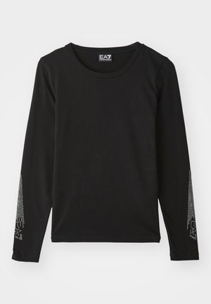 Zwarte langwerpige shirt met lange mouwen, gemaakt van zacht materiaal, met een ronde halslijn en zilveren versieringen langs de mouwen in een verlopend patroon.
