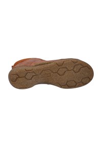 Semelle de chaussure en cuir tan avec un dessous en caoutchouc brun texturé présentant un motif hexagonal, indiquant une adhérence sur diverses surfaces.