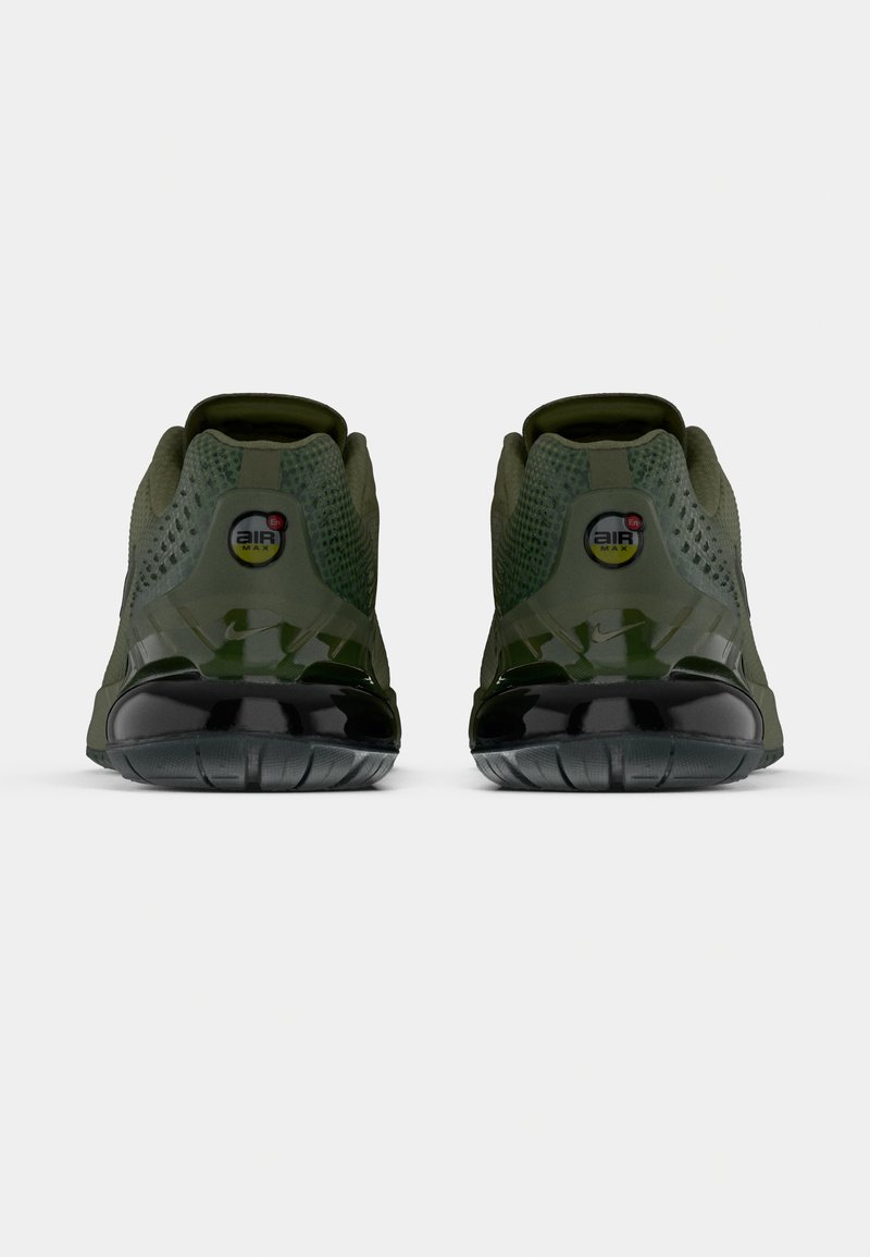 Green athletic shoes with a textured mesh upper, black accents on the sole, and an Air Max logo on the heel. Rounded, padded collar design.