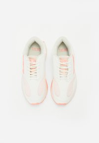 White athletic shoes with mesh and smooth textile uppers, featuring pink accents on the sides and soles, and traditional lace-up design.