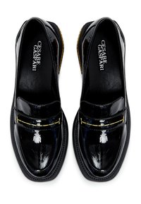 Mocassins en cuir verni noir avec une bande d'accent dorée sur le dessus, une forme à bout arrondi et une semelle plateforme noire texturée.