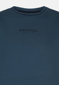 Námornícky modré bavlnené tričko s okrúhlym výstrihom a jemne embossovaným logom "PETROL" na prednej strane. Hladká textura s krátkymi rukávmi.