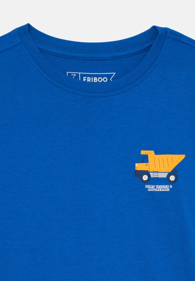 T-shirt in cotone blu con colletto rotondo, decorata da una grafica di un camion ribaltabile giallo e la scritta "DUMP TRUCKS & DAYDREAMS" in bianco.