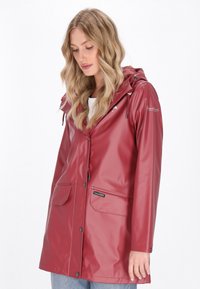 Punainensateinen vesitiivis takki hupulla, nepparilla varustettuna, kahdella etutaskulla ja sileällä kiiltävällä pinnalla. Hupussa on narukiristys.