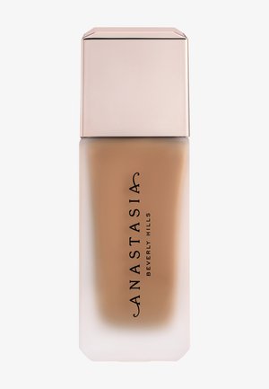 Flacon de fond de teint en verre dépoli, liquide beige à l'intérieur, avec un bouchon rectangulaire rose clair, étiqueté "Anastasia Beverly Hills".