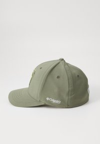Căciulă de baseball verde cu un bor decorat, fabricată din țesătură. Are un logo brodat pe partea din față și o etichetă pe lateral.
