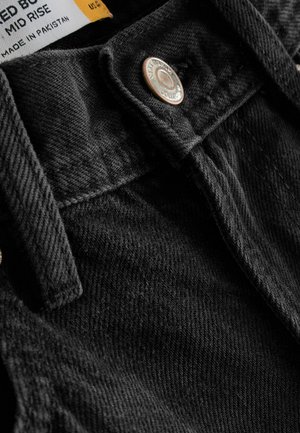 Mitellånga svarta denimjeans med en strukturerad yta, som har en bronssfärgad knapp och sömdetaljer vid midjan.