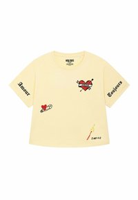 Geel cropped T-shirt met korte mouwen, met rode geborduurde hartontwerpen, veiligheidsspeld, sigaretten, en tekst: "Amour" en "Toujours."