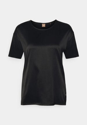 T-shirt noir en satin à manches courtes avec col rond et petite étiquette à l'intérieur du col arrière sur fond blanc.