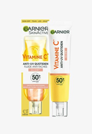 Fluide anti-UV quotidien à la vitamine C Garnier SkinActive, tube blanc avec accents oranges, accompagné d'un contenant jaune transparent, SPF 50+.