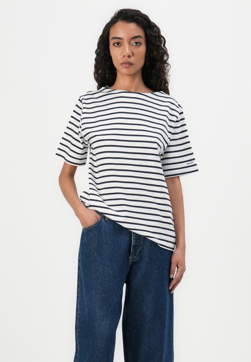 Gestreiftes, kurzärmliges T-Shirt in Weiß und Marineblau, mit entspannter Passform, Rundhalsausschnitt und dezentem Markenlogo auf dem Ärmel.