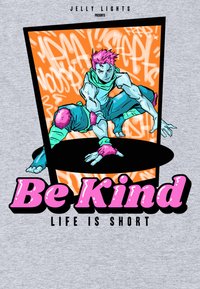 Grafický tričko s živou ilustrací postavy s růžovými vlasy v dynamické póze na oranžovém pozadí. Text zní: "Buď laskavý, život je krátký."