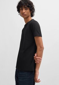 Sort crewneck t-shirt med korte ærmer, lavet af blødt bomuldsstof. Har en klassisk pasform, minimalistisk design og ingen synlige mønstre eller hardware.