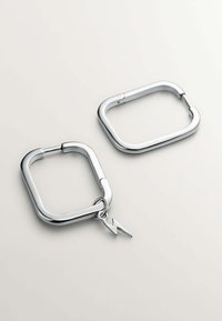 Pendientes de aro de metal plateado, forma rectangular, con un acabado pulido, que presentan un pequeño charm de rayo adjunto a uno de los aros.