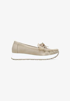 Mocasín beige con puntera cosida, lazo decorativo y suela gruesa de goma blanca, mostrado de perfil sobre un fondo blanco.