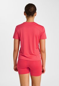 Kortærmet atletisk top og tætsiddende shorts i lyserød, lavet af glat, elastisk materiale. Har en rund halsudskæring og en behagelig pasform.