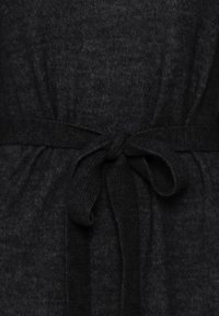 Indumento lavorato a maglia nero con cintura a fiocco, che mette in evidenza una texture morbida e un delicato motivo melangiato. Focus sul tessuto e sul dettaglio legato a mano.