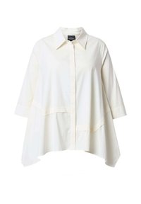 Camicia bianca oversize con colletto e maniche lunghe. Presenta una chiusura frontale con bottoni, orlo dritto e una texture sottile.