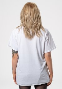 White unisex t-shirt made of cotton, featuring a relaxed fit, short sleeves, and a plain back without any graphics or patterns.